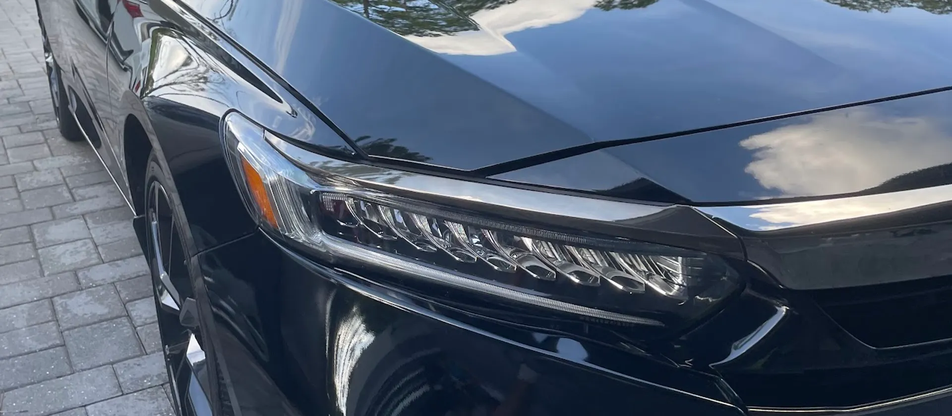 Glossy black sedan with mirror-like paint finish after professional detailing by Sansanich Car Detailing in North Port, FL